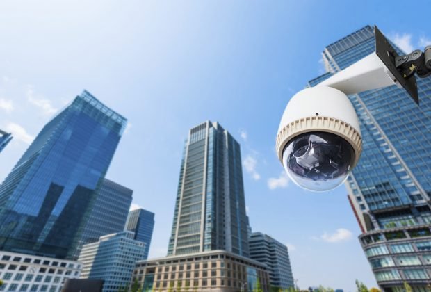 CCTV Camera or surveillance oeprating with building in backgroun